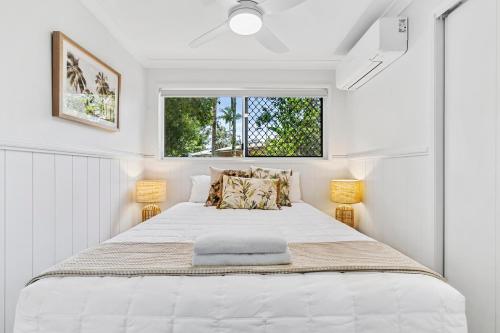 a white bedroom with a large bed with a window at Ingenia Holidays Kinka Beach Yeppoon in Kinka