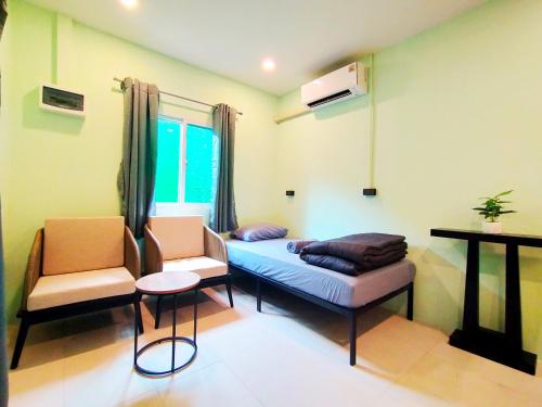 a living room with a bed and a chair at Palm Garden house 1 close to Bang Tao beach in Ban Phak Chit