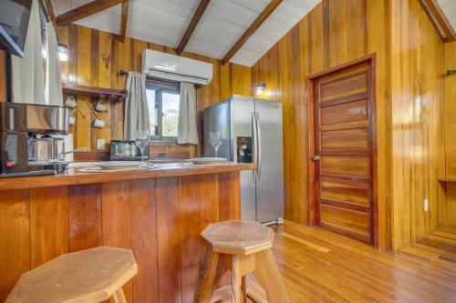 Una cocina con paredes de madera y un mostrador y un refrigerador. en Kmar Villas, en Placencia Village