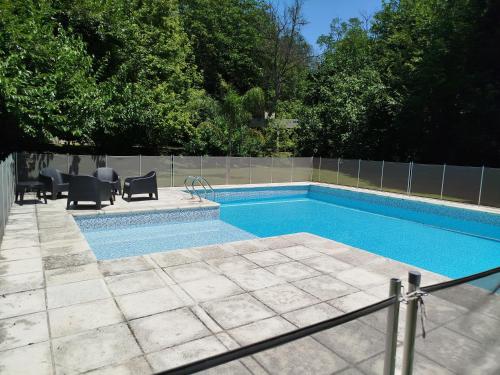 a swimming pool in a yard with chairs around it at Cabañas El Ceibo in Villa la Bolsa