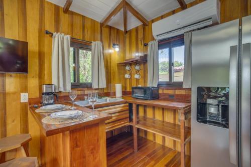 Una cocina con paredes de madera y un refrigerador de acero inoxidable. en Kmar Villas, en Placencia Village
