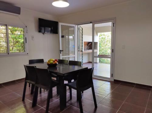 a dining room with a black table and chairs at Cabañas El Ceibo in La Bolsa