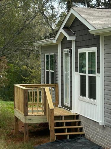 a tiny house with a porch and a deck at Panther Creek retreat in Clarkesville