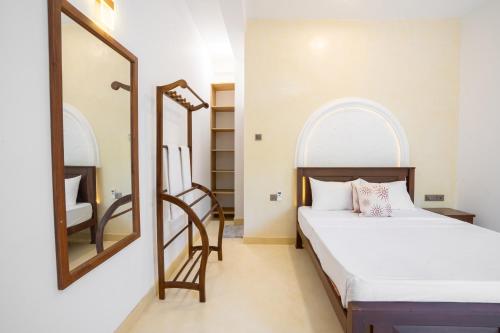 a bedroom with a bed and a mirror at Medawatta Villa in Mirissa