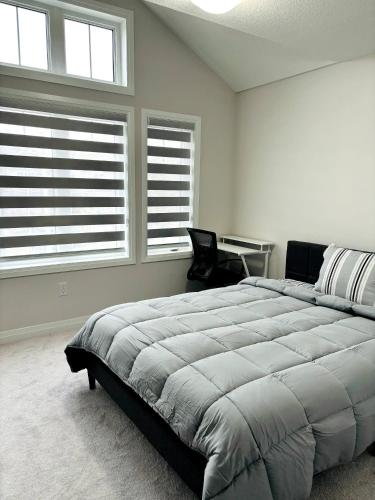 Un dormitorio con una cama grande y dos ventanas. en Cozy Room in Ayr, en Paris