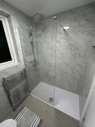a shower with a glass door in a bathroom at Luxury apartment in Guildford in Guildford