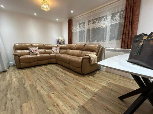 ein Wohnzimmer mit einem braunen Ledersofa in der Unterkunft Luxury apartment in Guildford in Guildford