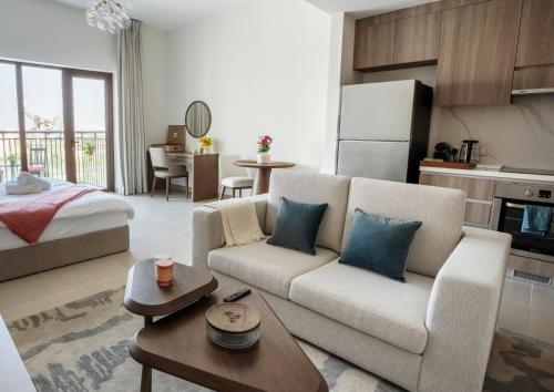a living room with a couch and a table at Yas Park View Studio Abu Dhabi Yas Island in Abu Dhabi