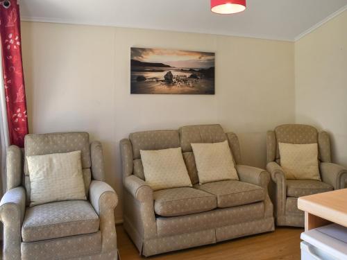 ein Wohnzimmer mit zwei Stühlen und einer Couch in der Unterkunft Harbour Cove - Uk47722 in Saint Merryn