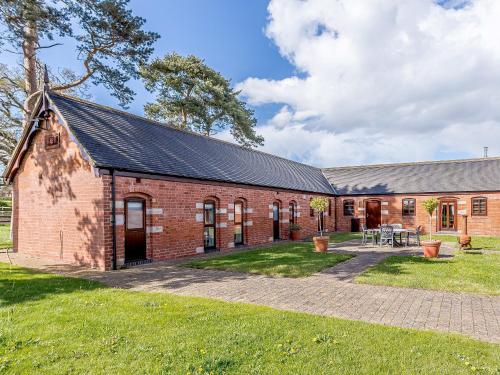 an old red brick building with a courtyard at Low Barn in Market Bosworth