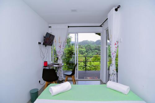 een slaapkamer met een bed en uitzicht op een balkon bij Mist of Sinharaja in Galle