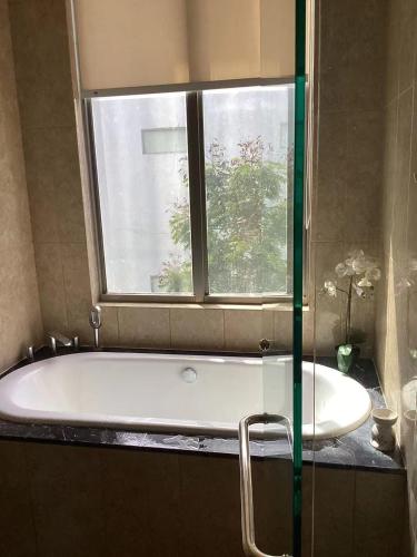 a bath tub in a bathroom with a window at sea l in Jakarta