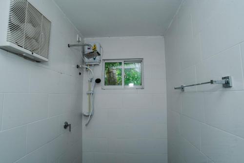 een witte badkamer met een douche en een raam bij Mist of Sinharaja in Galle