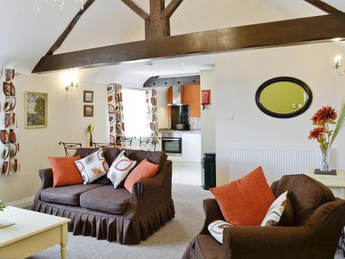 a living room with two couches and a table at Granary Cottage in Penrhyn Bay