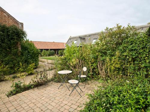 two chairs and two tables in a garden at Thyme - E4485 in Ludham