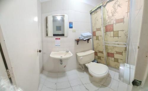 a white bathroom with a toilet and a sink at Hotel Lord by Croma in Cúcuta