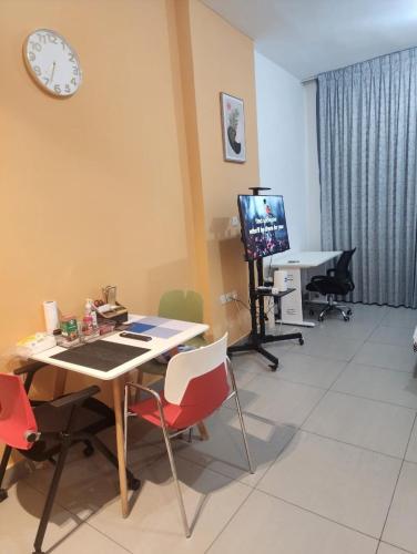 een kamer met een tafel en stoelen en een klok aan de muur bij lenexusholidayhomes in Sharjah