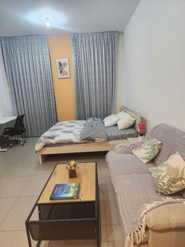 een woonkamer met twee bedden en een salontafel bij lenexusholidayhomes in Sharjah