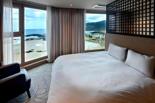 a bedroom with a large bed and a large window at Ebenezer Hotel in Jeju