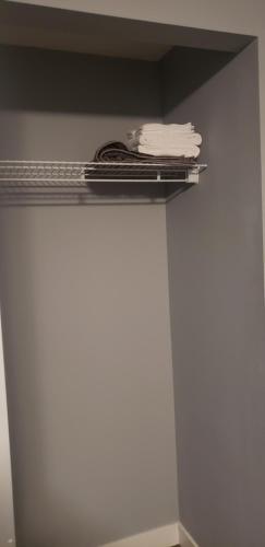 a shelf with a stack of towels on a wall at Room to stay in Lethbridge