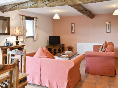 Una sala de estar con un sofá y un televisor en Sorrel - E4321, en Ludham