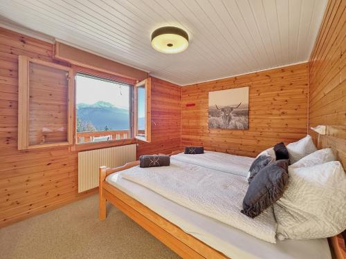 a bedroom with a bed in a room with wooden walls at Mirador Lodge - Crans Montana - Swiss Alps in Randogne