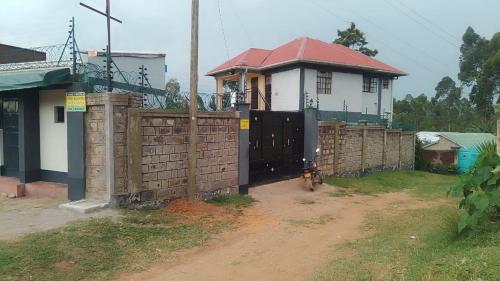 a small house with a gate and a fence at DADESA Pl in Kakamega