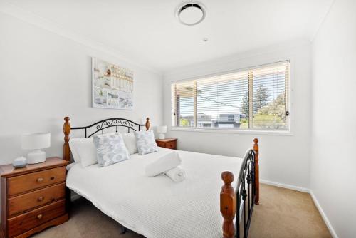 un dormitorio con una cama y una ventana en Sandy Adventures - Pet Friendly - 1 Min to Beach, en Callala Beach
