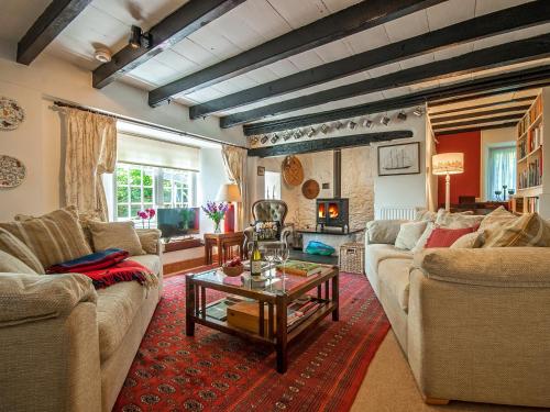 a living room with two couches and a table at Llys Isaf in Saint Nicholas