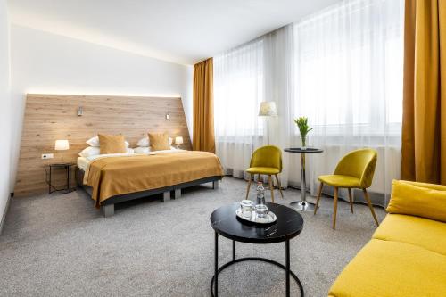a hotel room with a bed and a table and chairs at Primma Hotel in Moldava nad Bodvou
