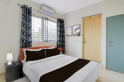 KammasandraにあるCollection O REVA University Rukmini Knowledge Parkの大きなベッドと窓のある寝室