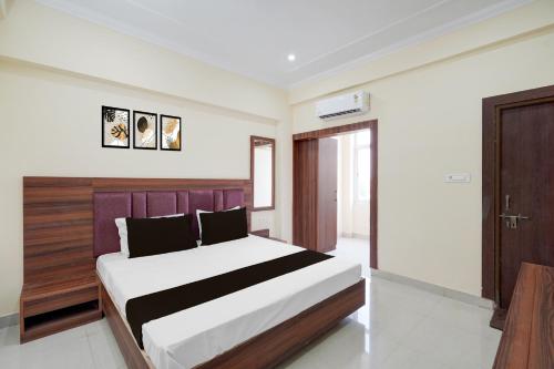 a bedroom with a large bed with a wooden headboard at Collection O Ranipur - Dhaney Crossway Formerly Saroj Inn in Bhāda