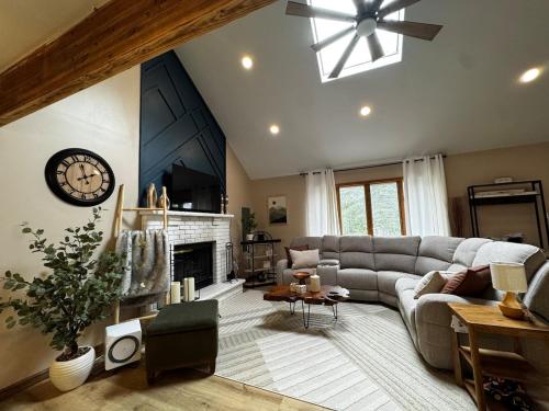 un salon avec un canapé et une horloge au mur dans l'établissement Pocono Mountain Chalet, à Tobyhanna