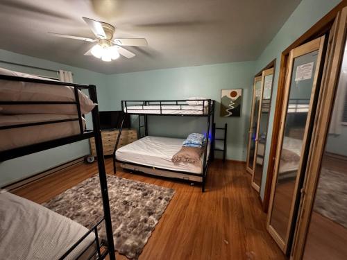 une chambre avec deux lits superposés et un ventilateur de plafond dans l'établissement Pocono Mountain Chalet, à Tobyhanna