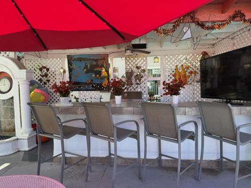 a restaurant with a table and chairs under a red umbrella at Casa Larrea Inn in Palm Desert