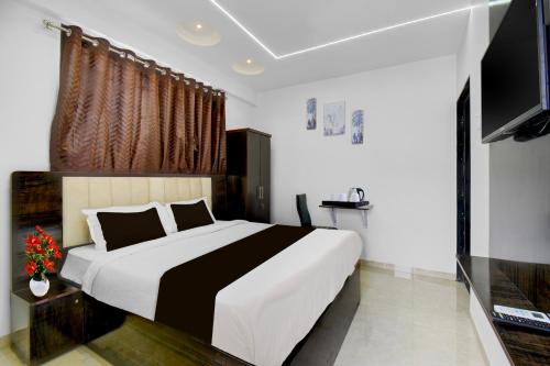 a bedroom with a large bed and a flat screen tv at Super Townhouse Pimple Nilakh Pune in Dāpuri