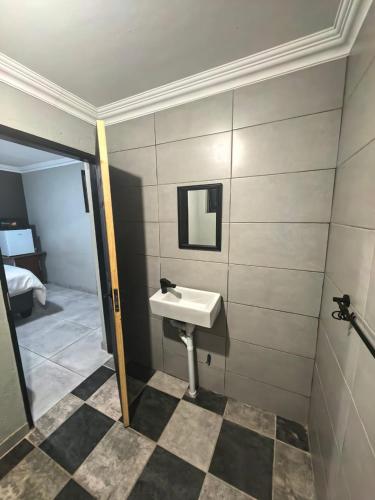a bathroom with a sink and a mirror at The Good Samaritan 1 in eMalahleni