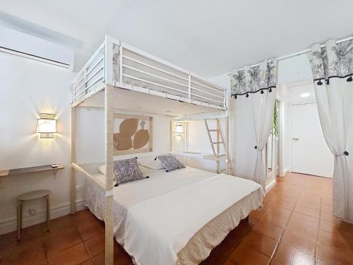 a bedroom with a white bunk bed in a room at Ti Mabouya Appartement Saint François in Saint-François