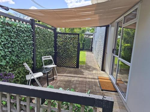 a patio with a fence and a chair at Private Self Contained Unit in Claudelands
