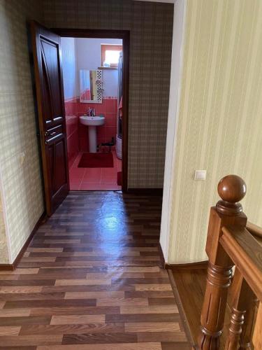 ein Flur mit einem Badezimmer mit Waschbecken und Toilette in der Unterkunft Гостевой дом с 7 комнатами in Schymkent