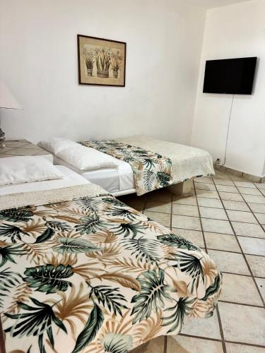 a room with two beds and a tiled floor at Majaguar Hotel Boutique in Cancún