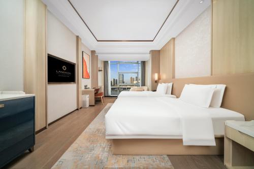 a hotel room with two beds and a bathroom at Landison Plaza E-Fashion Hotel Hangzhou in Hangzhou