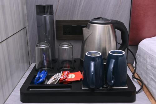 a tray with a coffee maker and cups on a table at Sunaina Palace in Varanasi