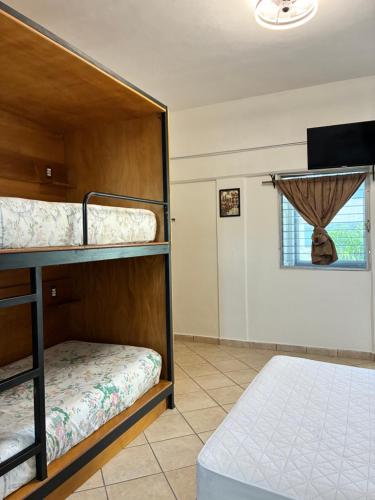 a room with two bunk beds and a window at Majaguar Hotel Boutique in Cancún