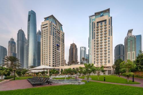 a park in a city with tall buildings at Al Habtoor Grand Resort, Autograph Collection in Dubai