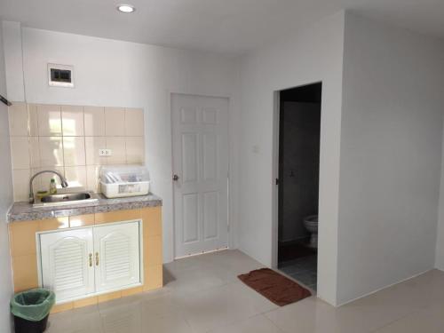 バンタオビーチにあるBangtao Mango Houseのキッチン(シンク付)、トイレが備わります。