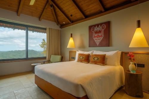 Greenpark Resort and Spa, Madikeri في ماديكيري: غرفة نوم بسرير كبير ونافذة كبيرة