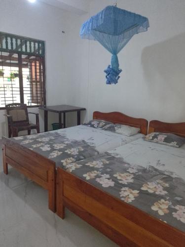 a bedroom with a bed with a blue umbrella on the wall at Niluka Rest in Kataragama
