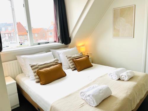 two twin beds in a room with a window at Multi-bedroom Stay, 9 Rooms Near Beach in Zoutelande