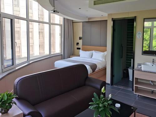 a hotel room with a bed and a couch at Green Tree Inn Express Tangshan Kaiping District Government in Dachadao